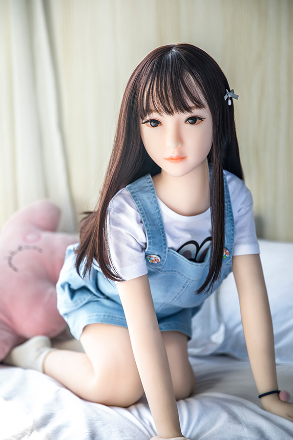 5 製品ページ:100cm超美少女ラブドール美代、デニムオーバーオール着用、TPE製、ベッドに座る、柔らかな質感.