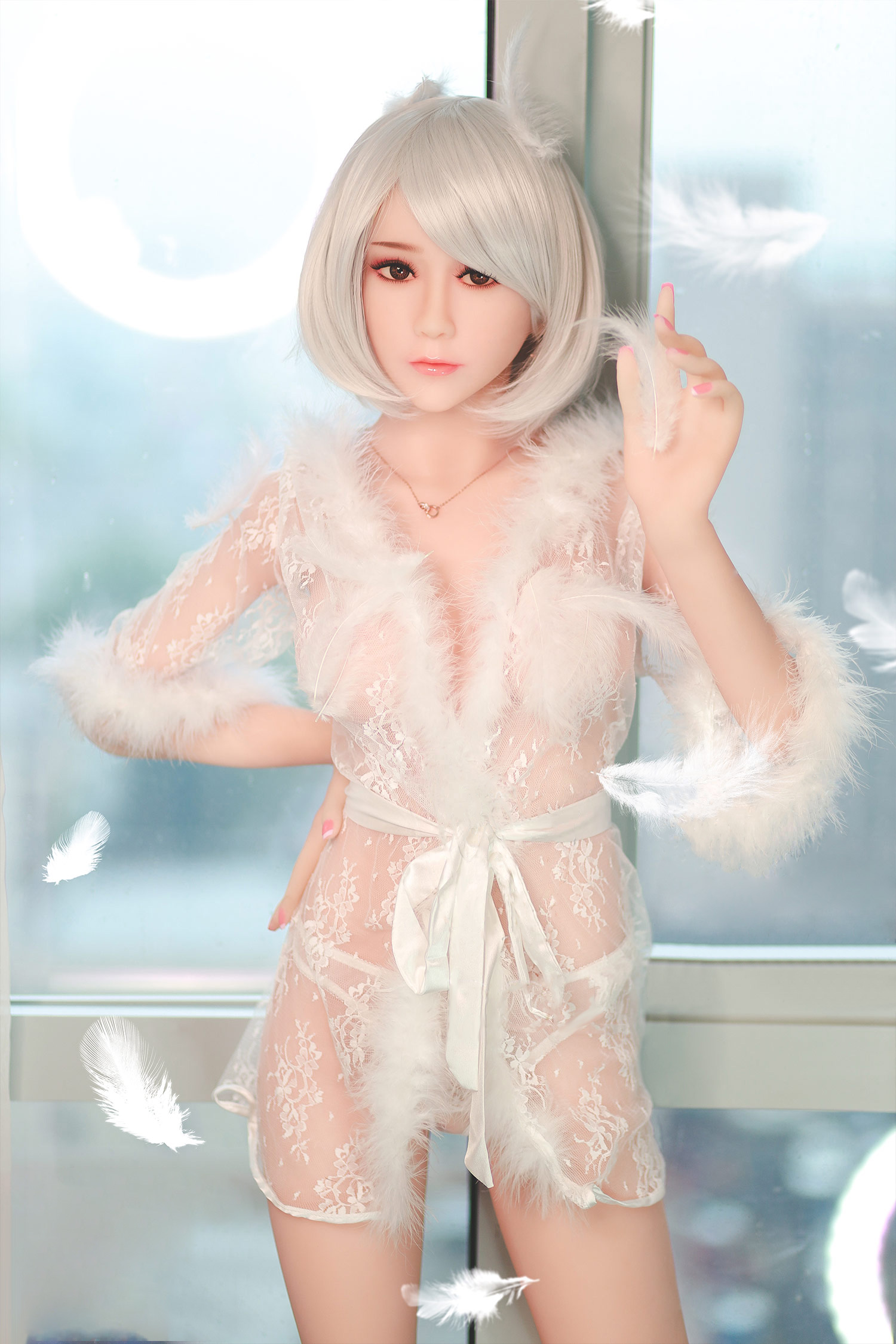 1 清楚少女系リアルドール 優美子 148cm、白いレースと羽飾りのランジェリー着用。窓辺で白い羽根を持ち、優しく見つめる。全景商品写真。.